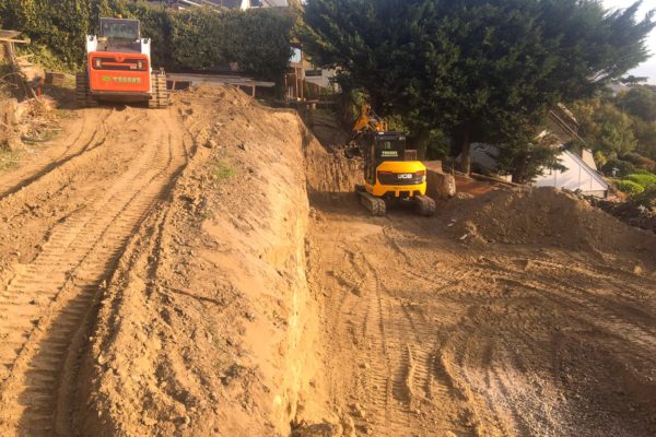 Bobcat And Excavator Begin Earthmoving And Land Clearing For Concrete Driveway On Hill