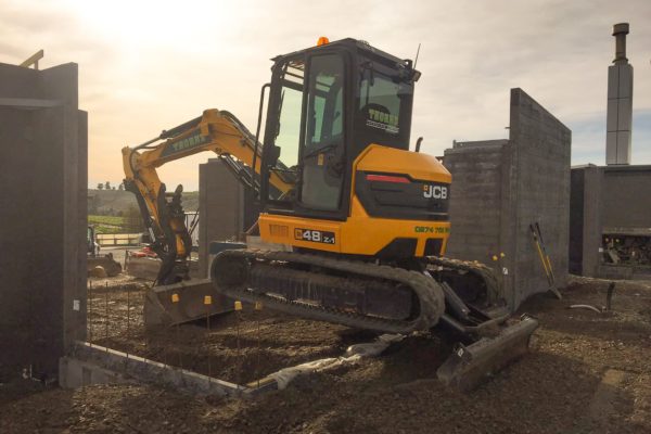 Thornz Landscapes Z48 JCB EXcavator On Site Preparing Ground Between Concrete Walls