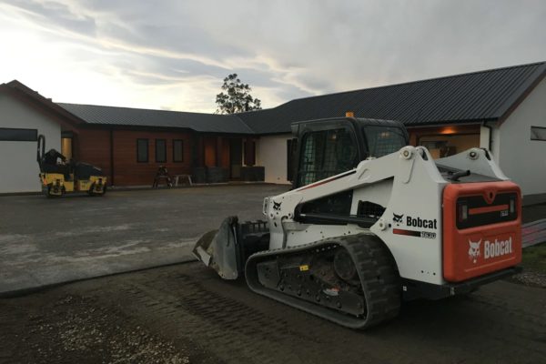 Bobcat and Roller On Site Preparing Ground For Concrete Driveway